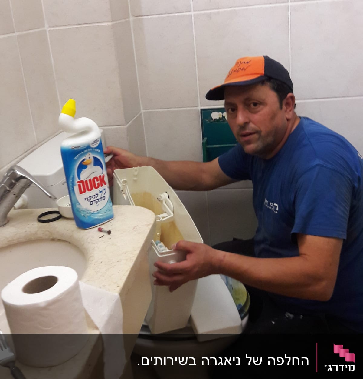 אדם מתקן אסלה בחדר אמבטיה